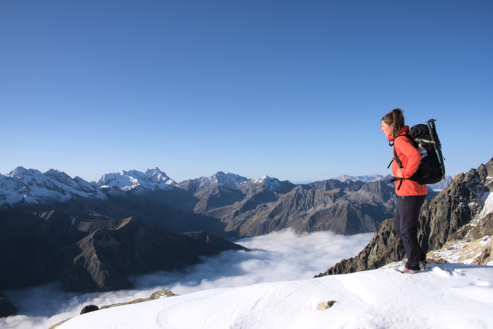 Hiker on a ridge above a sea of clouds, Valgaudemar