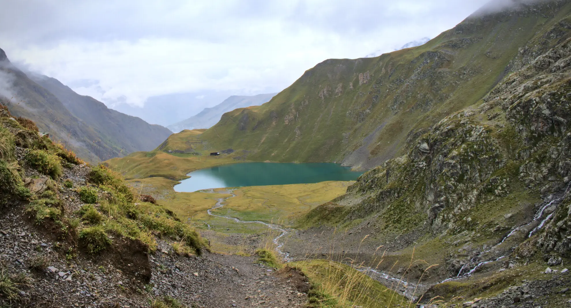 Lac de la Muzelle seen from the descent trail, with the refuge at the water's edge