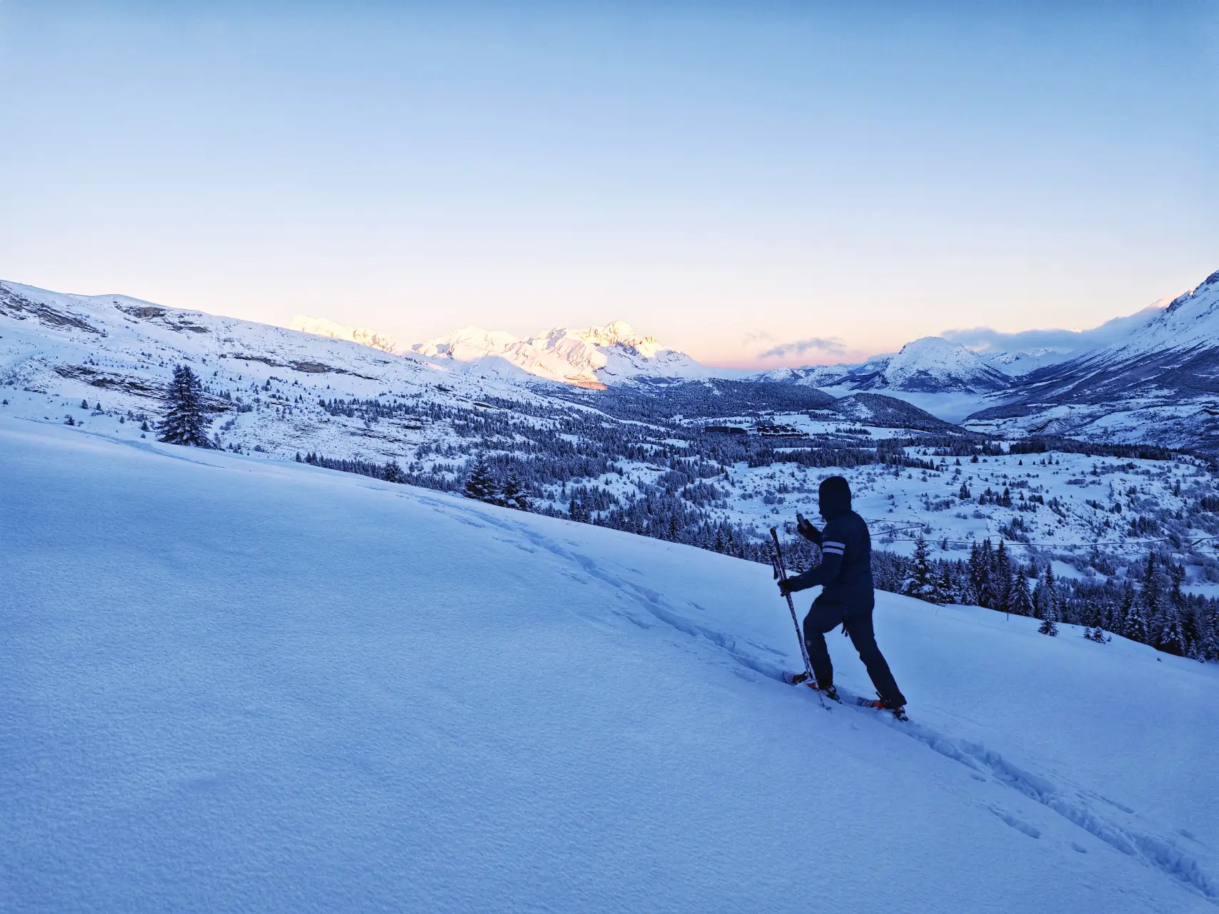 First steps on pristine snow, facing summits glowing at dawn in the Dévoluy massif